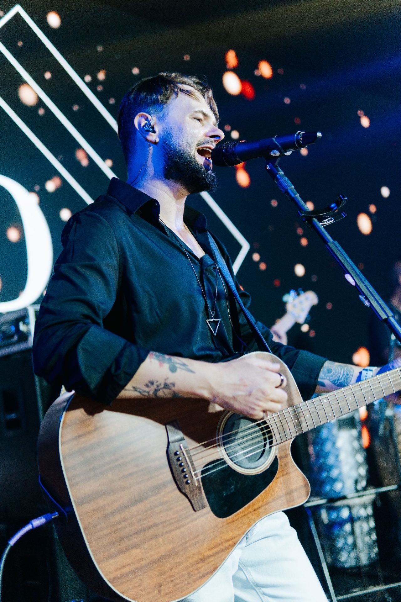 Thiago Melo cantando ao violão no palco