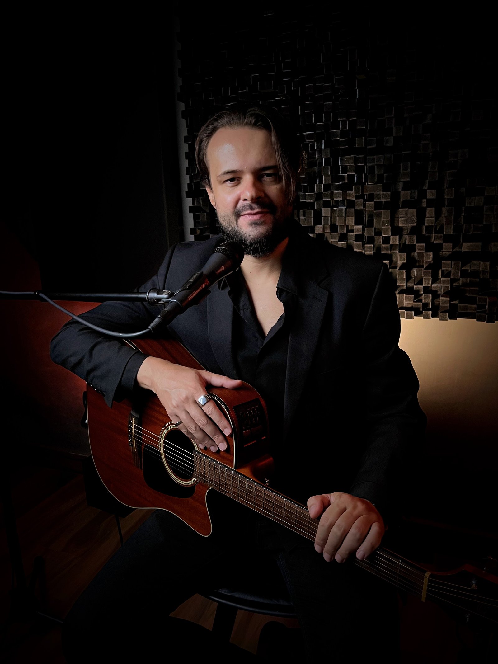 Thiago Melo no estúdio, ao microfone com violão